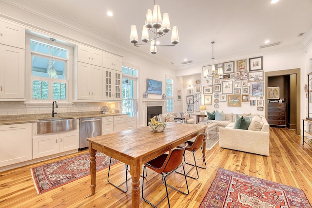 312 Hobcaw Dr, Mount Pleasant, SC 29464 - dining space with a chandelier, light wood-type flooring, ornamental molding, a fireplace, and recessed lighting