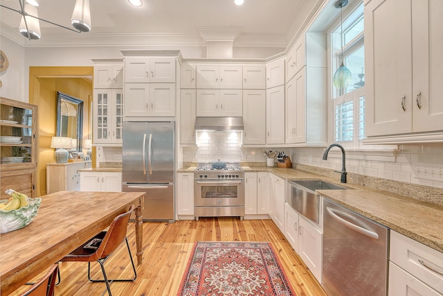 312 Hobcaw Dr, Mount Pleasant, SC 29464 - kitchen featuring appliances with stainless steel finishes, a sink, crown molding, range hood, and white cabinets