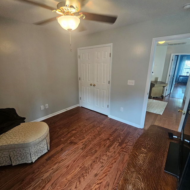 living area with ceiling fan and dark hardwood / wood-style floors