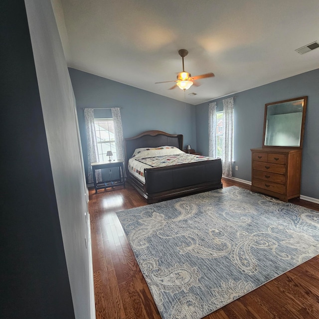 bedroom with lofted ceiling, dark hardwood / wood-style floors, and ceiling fan