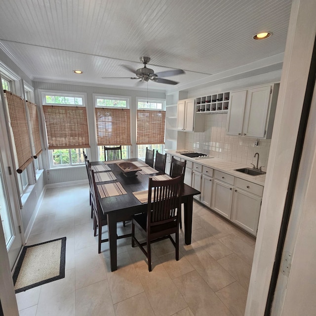 dining room with ceiling fan, light tile patterned floors, and sink