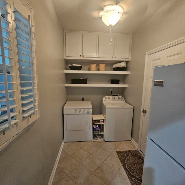 laundry area with cabinets, light tile patterned floors, and washing machine and dryer