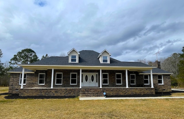 view of front of home featuring a front yard, crawl space, brick siding, and covered porch