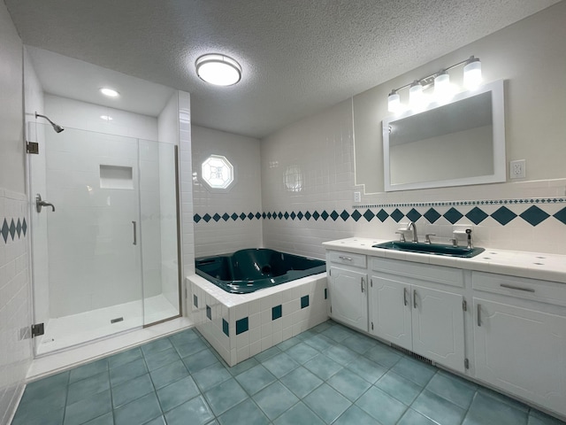 bathroom with tile walls, a shower stall, vanity, a bath, and tile patterned floors