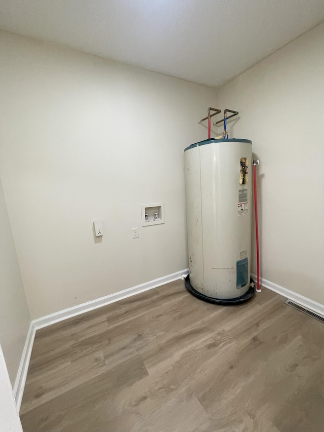 utility room featuring water heater and visible vents