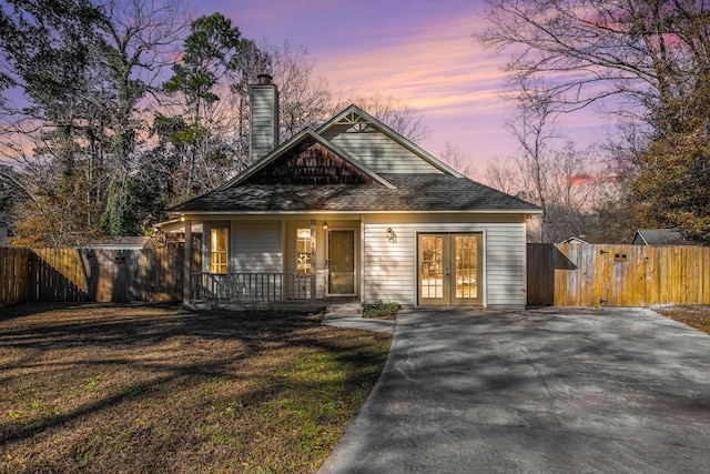 view of front facade featuring covered porch and french doors