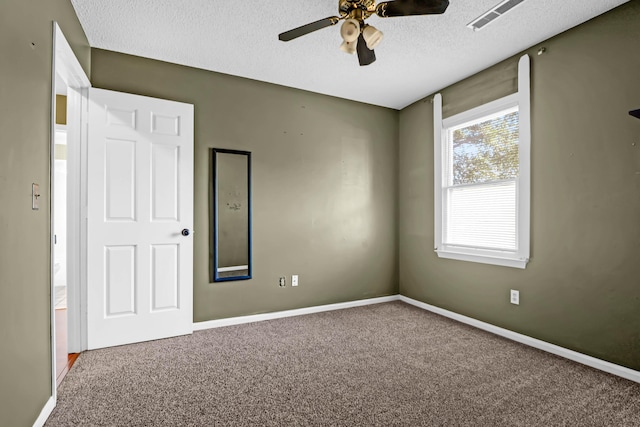 carpeted spare room with ceiling fan and a textured ceiling