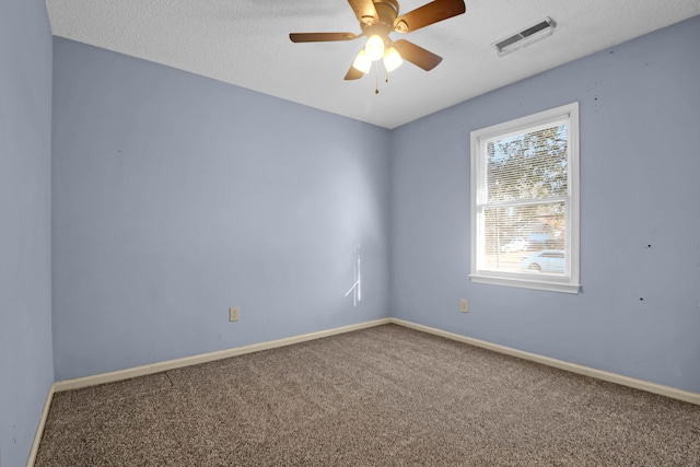 empty room with carpet flooring, ceiling fan, and a textured ceiling