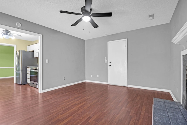 unfurnished living room featuring ceiling fan, dark hardwood / wood-style flooring, and a textured ceiling