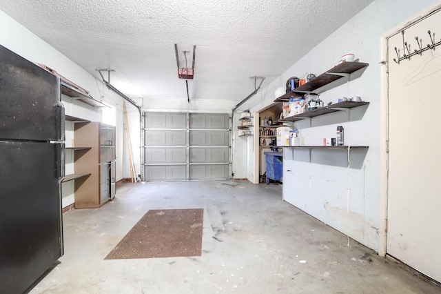 garage featuring black fridge and a garage door opener