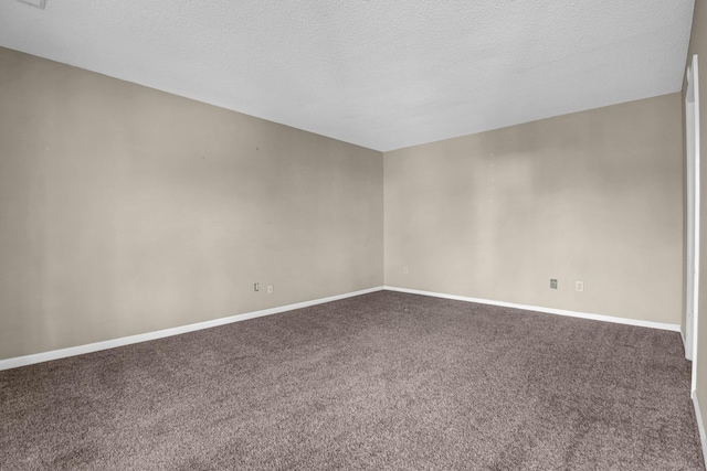 empty room with carpet flooring and a textured ceiling