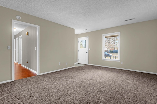 carpeted spare room with a textured ceiling