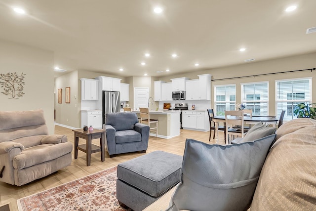 living room with sink and light wood-type flooring