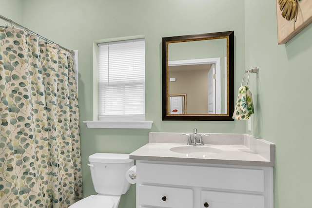 bathroom with a shower with shower curtain, vanity, and toilet