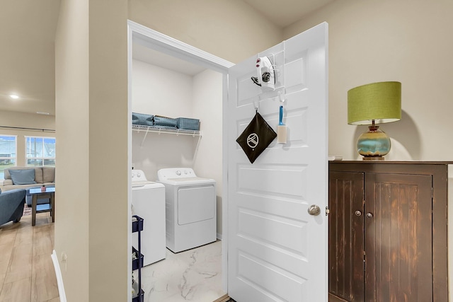 washroom with separate washer and dryer and light wood-type flooring