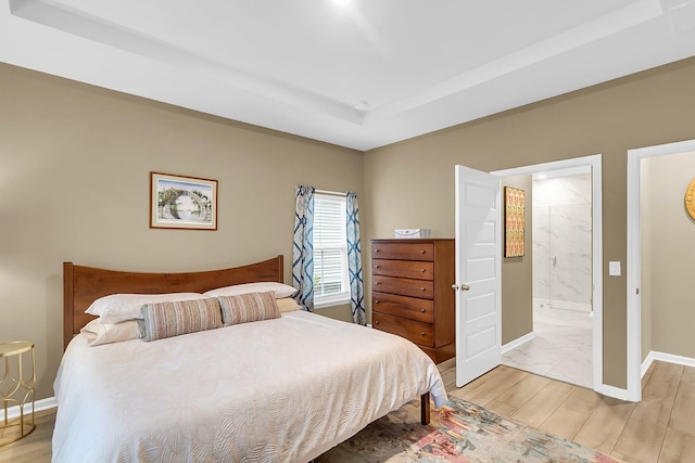 bedroom featuring hardwood / wood-style flooring and connected bathroom