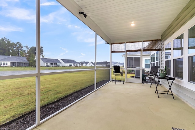 unfurnished sunroom with a water view