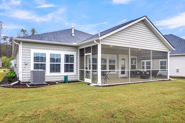 rear view of property featuring a lawn, central AC, a sunroom, and a patio area