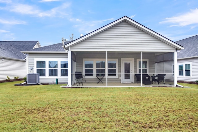 rear view of house with a patio area, central air condition unit, a sunroom, and a lawn