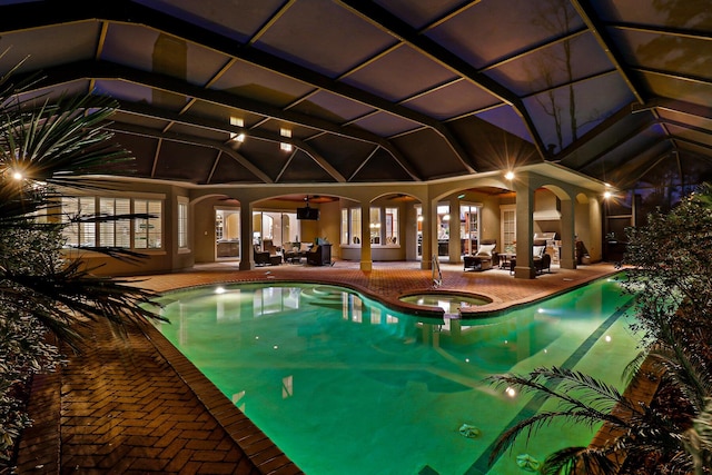 view of swimming pool featuring a patio area, a pool with connected hot tub, and glass enclosure