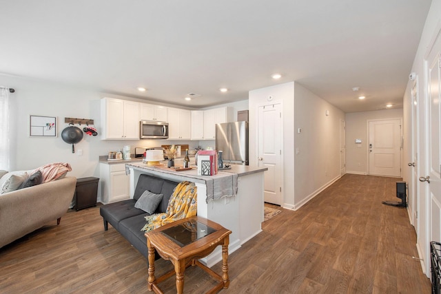 kitchen with stainless steel appliances, white cabinets, dark wood-type flooring, light countertops, and recessed lighting