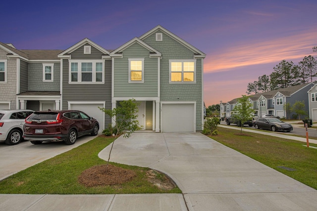 view of property featuring concrete driveway, an attached garage, a front lawn, and a residential view