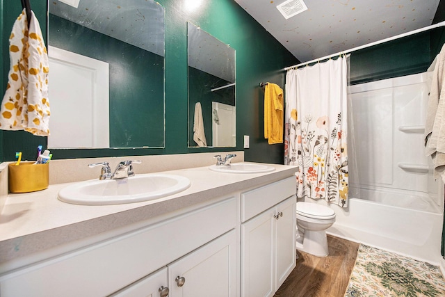 full bathroom with toilet, wood finished floors, double vanity, and shower / bathtub combination with curtain