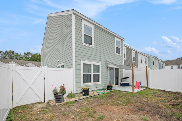 back of property featuring a gate, a patio area, and a fenced backyard