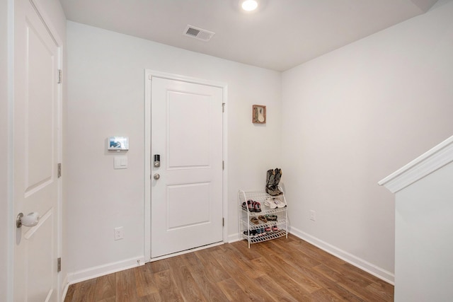 foyer entrance with wood finished floors and baseboards