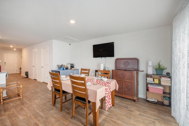 dining room featuring light wood finished floors, recessed lighting, and baseboards