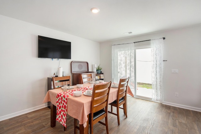 dining space featuring plenty of natural light, wood finished floors, and baseboards