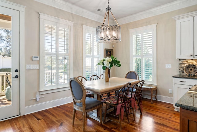 dining space with a chandelier, dark hardwood / wood-style floors, and ornamental molding