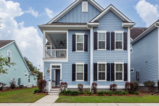 view of front of house with a front lawn, central air condition unit, and a balcony