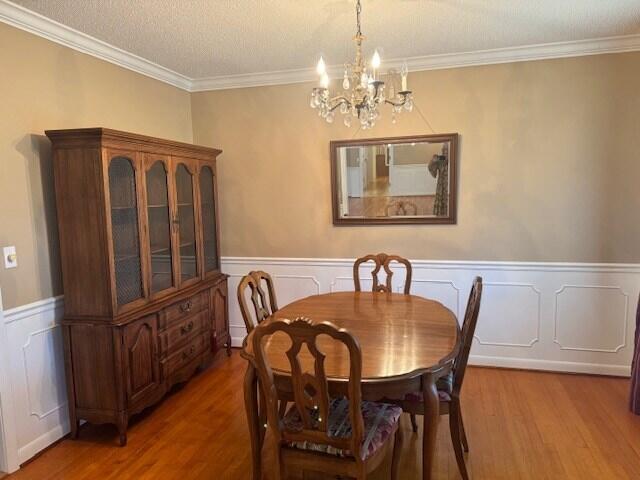 1153 Cherokee Dr, Manning, SC 29102 - dining room with a chandelier, wood finished floors, ornamental molding, and a wainscoted wall