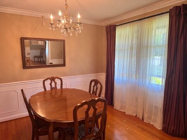 1153 Cherokee Dr, Manning, SC 29102 - dining room with wood finished floors, a chandelier, healthy amount of natural light, wainscoting, and crown molding