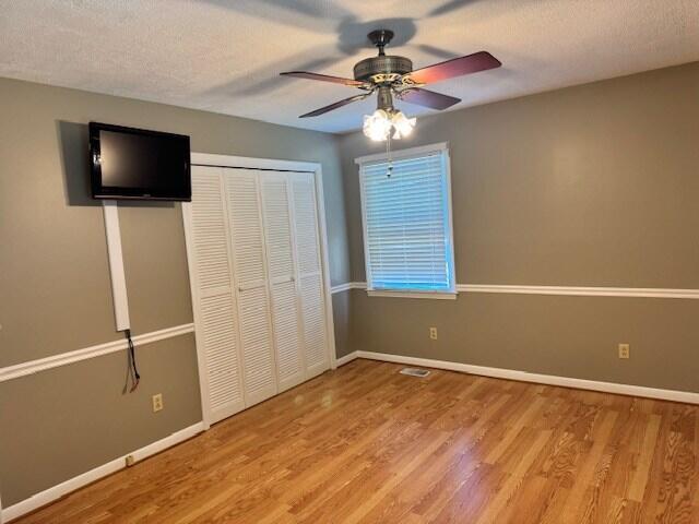 1153 Cherokee Dr, Manning, SC 29102 - unfurnished bedroom featuring wood finished floors, baseboards, a closet, and a textured ceiling