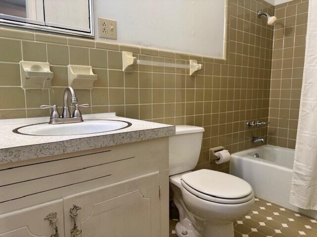 1153 Cherokee Dr, Manning, SC 29102 - full bathroom with vanity, shower / bath combination with curtain, toilet, and tile walls