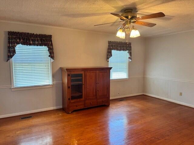 1153 Cherokee Dr, Manning, SC 29102 - empty room with wood finished floors, a ceiling fan, crown molding, and baseboards