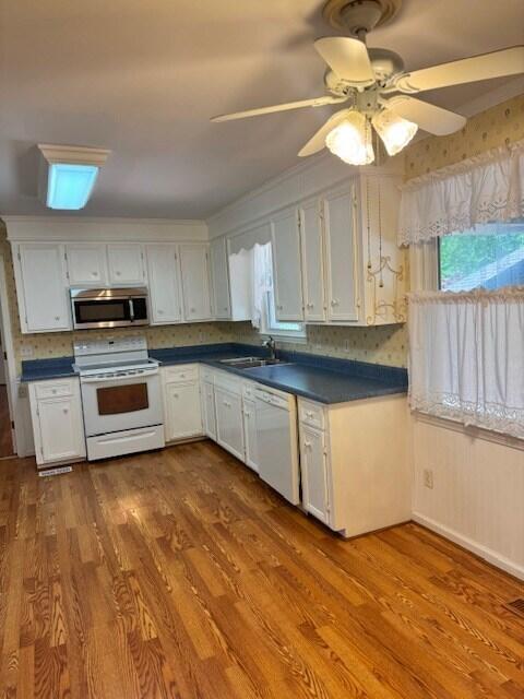 1153 Cherokee Dr, Manning, SC 29102 - kitchen featuring white appliances, dark countertops, a sink, and dark wood-type flooring