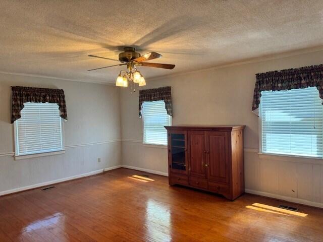 1153 Cherokee Dr, Manning, SC 29102 - empty room featuring wood finished floors, a textured ceiling, ceiling fan, baseboards, and crown molding
