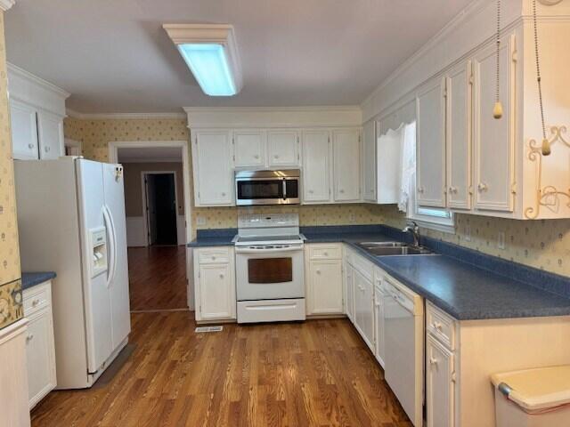 1153 Cherokee Dr, Manning, SC 29102 - kitchen with white appliances, a sink, dark countertops, white cabinetry, and dark wood-style flooring
