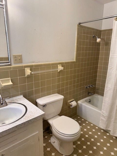 1153 Cherokee Dr, Manning, SC 29102 - bathroom featuring shower / tub combo with curtain, vanity, toilet, wainscoting, and tile walls