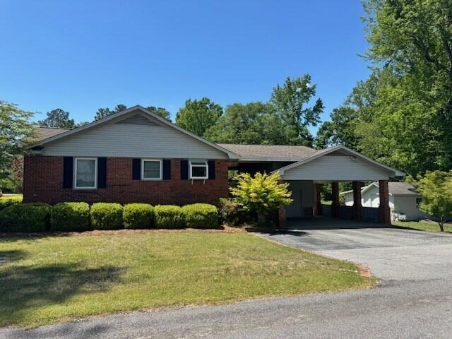 1153 Cherokee Dr, Manning, SC 29102 - ranch-style house with a front yard, driveway, and an attached carport