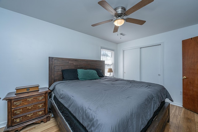 bedroom featuring light hardwood / wood-style flooring, a closet, and ceiling fan