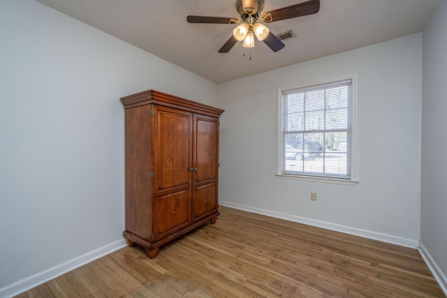 unfurnished bedroom with ceiling fan, light hardwood / wood-style floors, and a textured ceiling