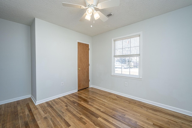 unfurnished room featuring hardwood / wood-style flooring, ceiling fan, and a textured ceiling