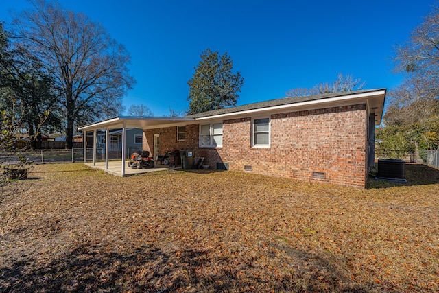 rear view of property featuring a patio area, central air condition unit, and a lawn