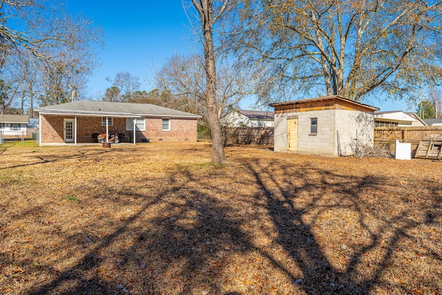 rear view of property featuring a storage shed, a yard, and a patio area