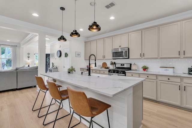 1576 Nautical Chart Dr, Charleston, SC 29414 - kitchen with stainless steel appliances, crown molding, a sink, light wood-type flooring, and a kitchen bar