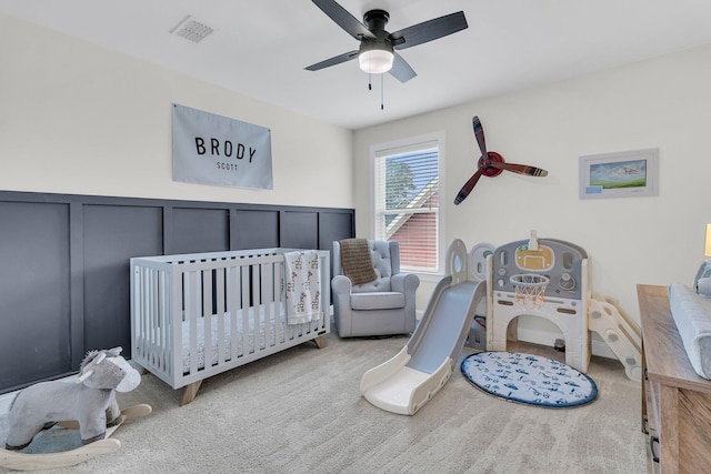 1576 Nautical Chart Dr, Charleston, SC 29414 - carpeted bedroom featuring a decorative wall, a crib, ceiling fan, and a wainscoted wall